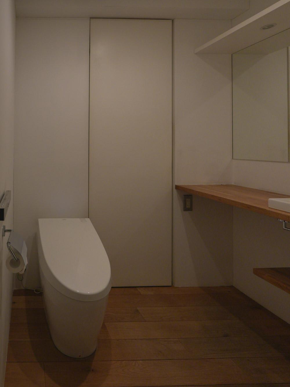 中野区中野の売買物件/洗面所の脇にウォシュレット付きトイレ。奥の引き戸の先が浴室