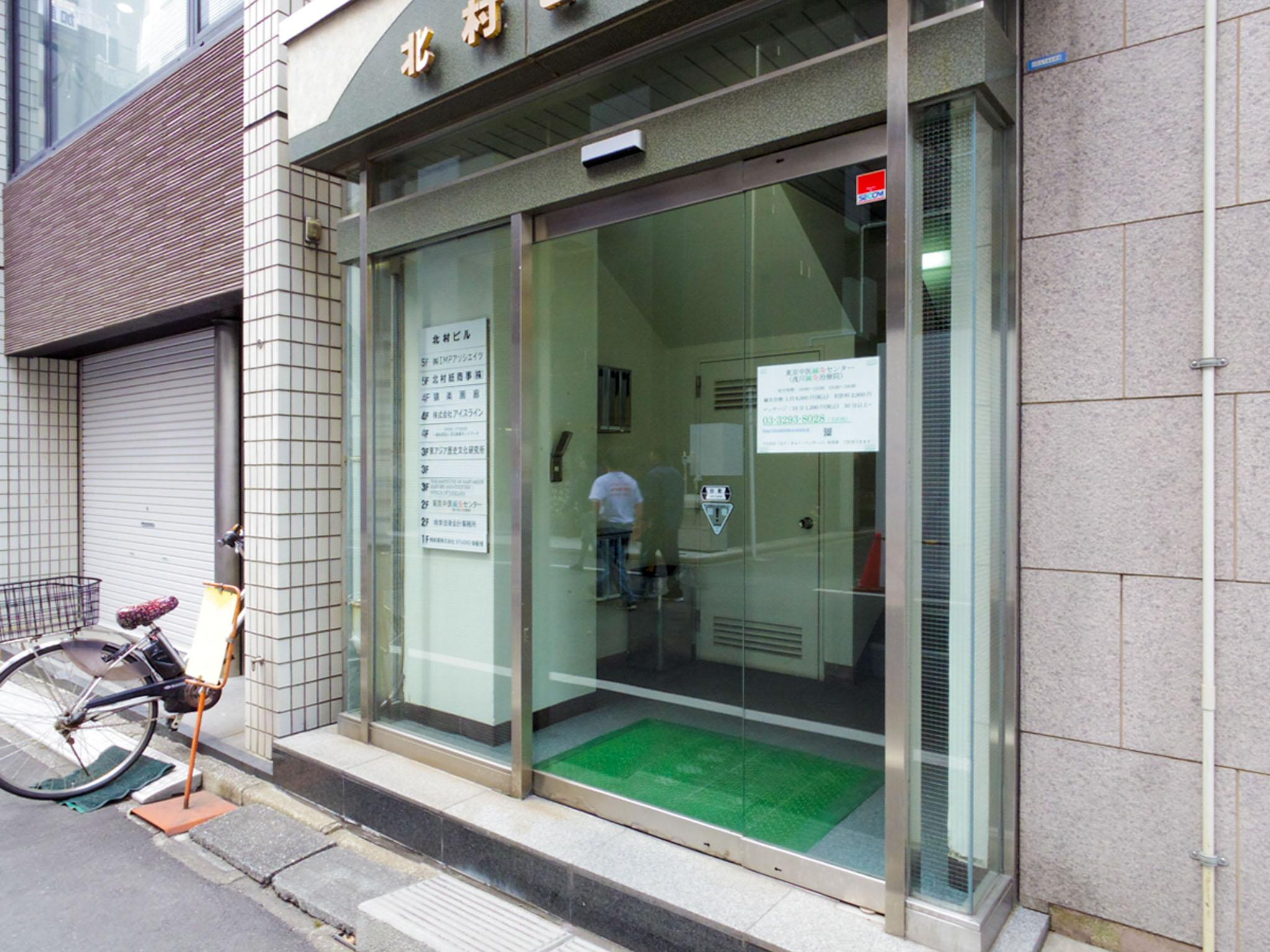 千代田区神田猿楽町の賃貸物件/自動ドアのエントランス。テナント案内板には弁護士事務所、建築設計事務所、デザイン事務所、レコーディングスタジオの名前が並ぶ