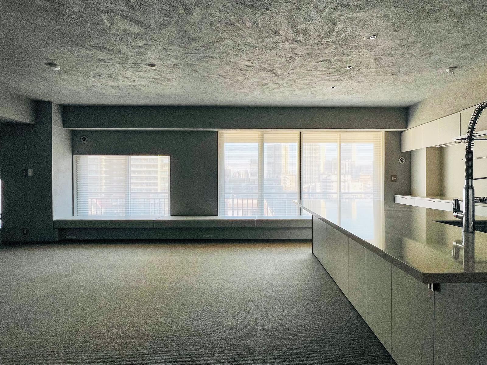 中央区月島の売買物件/壁と天井は漆喰とモルタルを混ぜた左官材で仕上げ、あえて質感を強調しています。天井はまるで月面のような雰囲気です