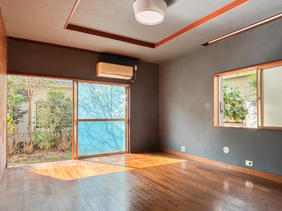 町田市忠生の賃貸物件/リビングには庭とつながる大きな窓。木の壁とグレーの壁紙で落ち着いた雰囲気