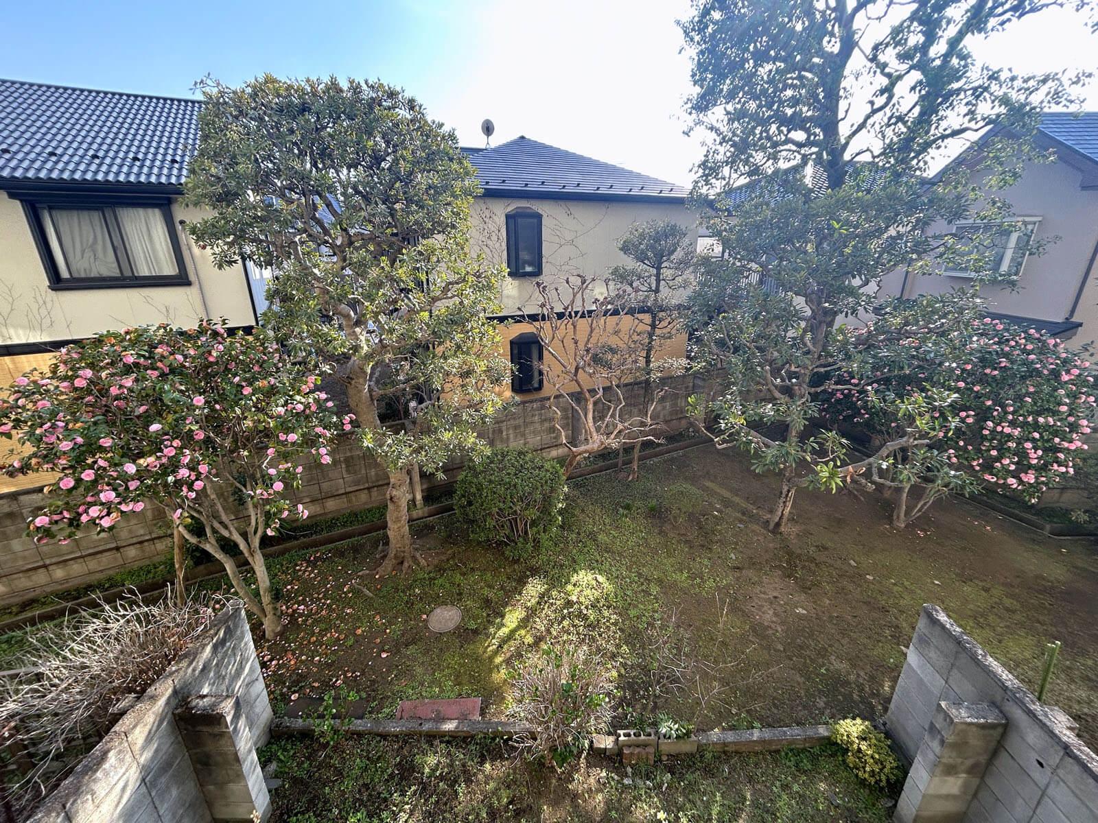 調布市国領町の売買物件/バルコニーから土の庭と木々を見下ろす平和な眺め