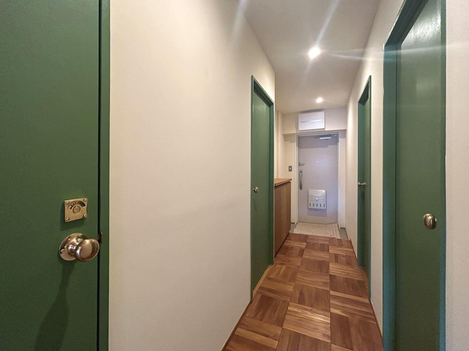 調布市国領町の売買物件/リビングから廊下に出るとグリーンの扉が勢揃い