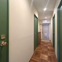 調布市国領町の売買物件/リビングから廊下に出るとグリーンの扉が勢揃い