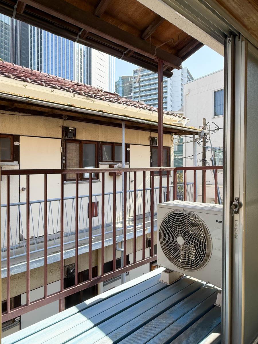 新宿区北新宿の賃貸物件/昭和なアパート越しに新宿の高層ビルを眺める