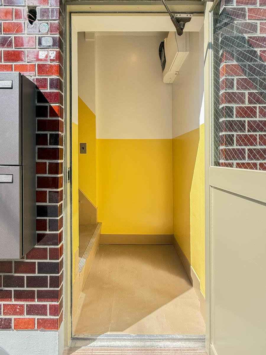 墨田区業平の賃貸物件/1階の扉をあけると黄色いアクセントカラーがかわいい階段室が待っています