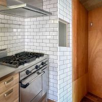 世田谷区池尻の売買物件/鋳物のレンジトップにオーブンがついた業務用レベルのキッチン。シンク側に冷蔵庫置き場（幅73cm）