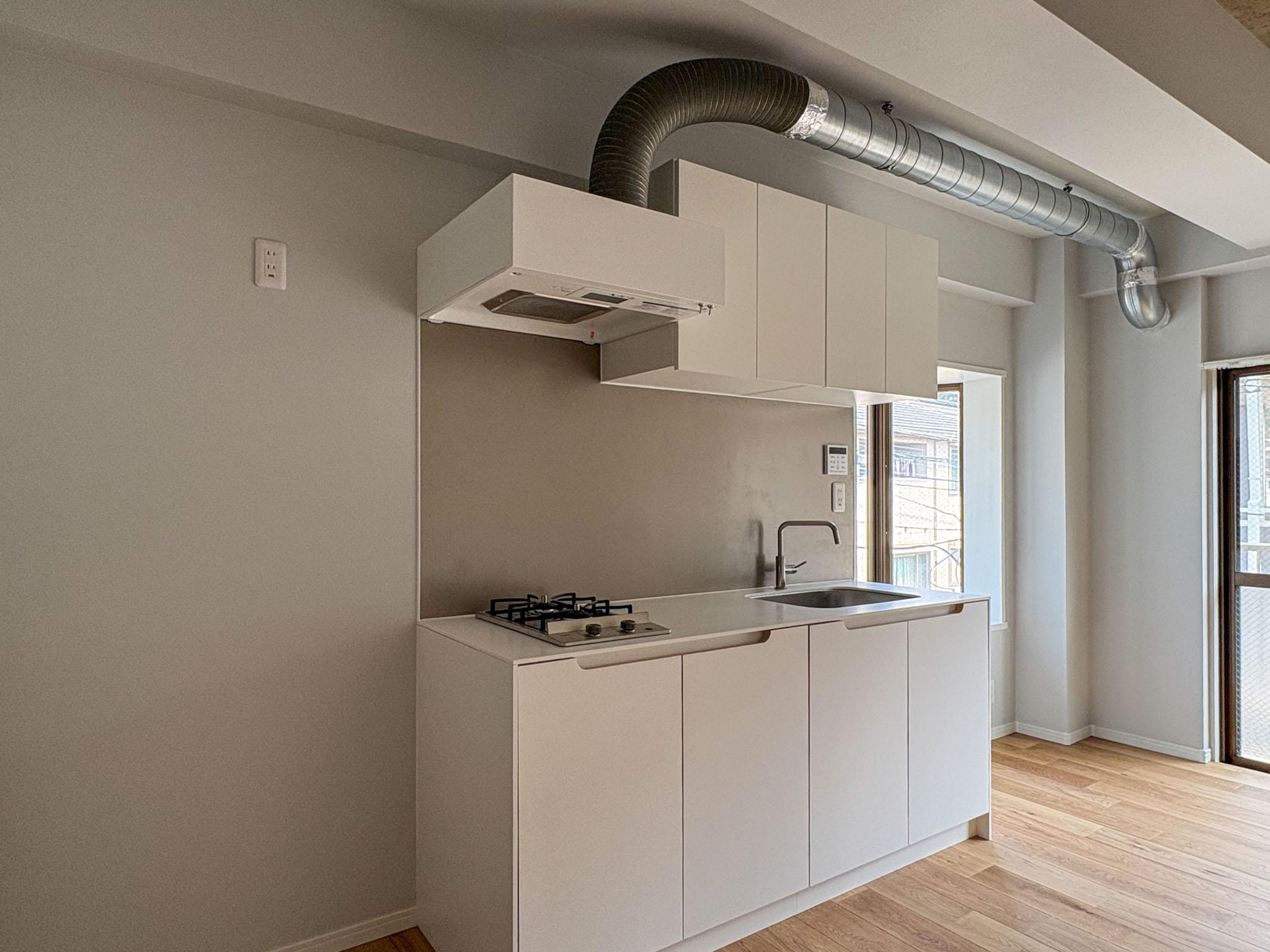 横浜市港北区菊名の賃貸物件/人工大理石の天板と手掛けのデザインが特徴的な収納力のあるキッチン。冷蔵庫置き場も、横にゴミ箱や収納などをまとめられるよう配置