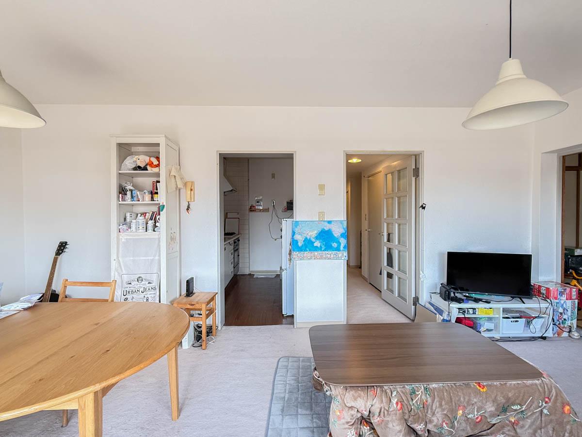 三鷹市下連雀の売買物件/窓側から梁のないスッキリしたリビングを見る。左の開口部はキッチン入口