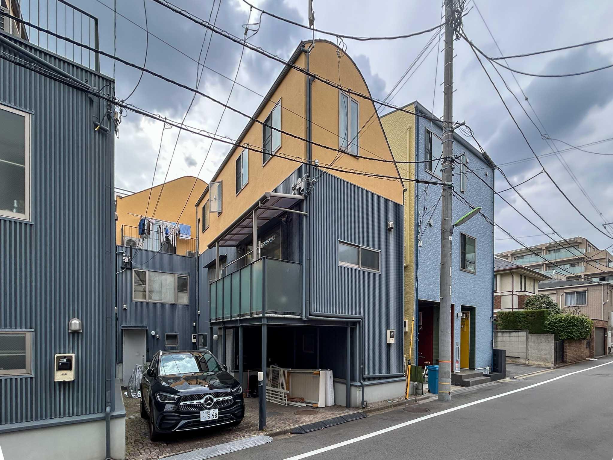 世田谷区用賀の賃貸物件/イエローとネイビーのツートンカラーの外観。同じデザインの戸建てが4棟並んでいます