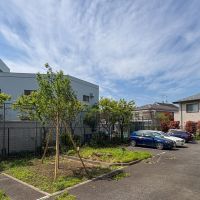三鷹市牟礼の売買物件/ベランダから駐車場方向への視点　マンションの人みんなでお花見をしたこともある大きな桜がありましたが、倒木の恐れがあり惜しまれながら数年前に伐採。けれど、また新しく桜を植えました。大きくなるのが待ち遠しい