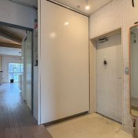 三鷹市牟礼の売買物件/玄関　白い大きな壁に見えるのは、実はLDKと玄関を仕切る引き戸。引き戸をスライドするとシューズクローゼットがある