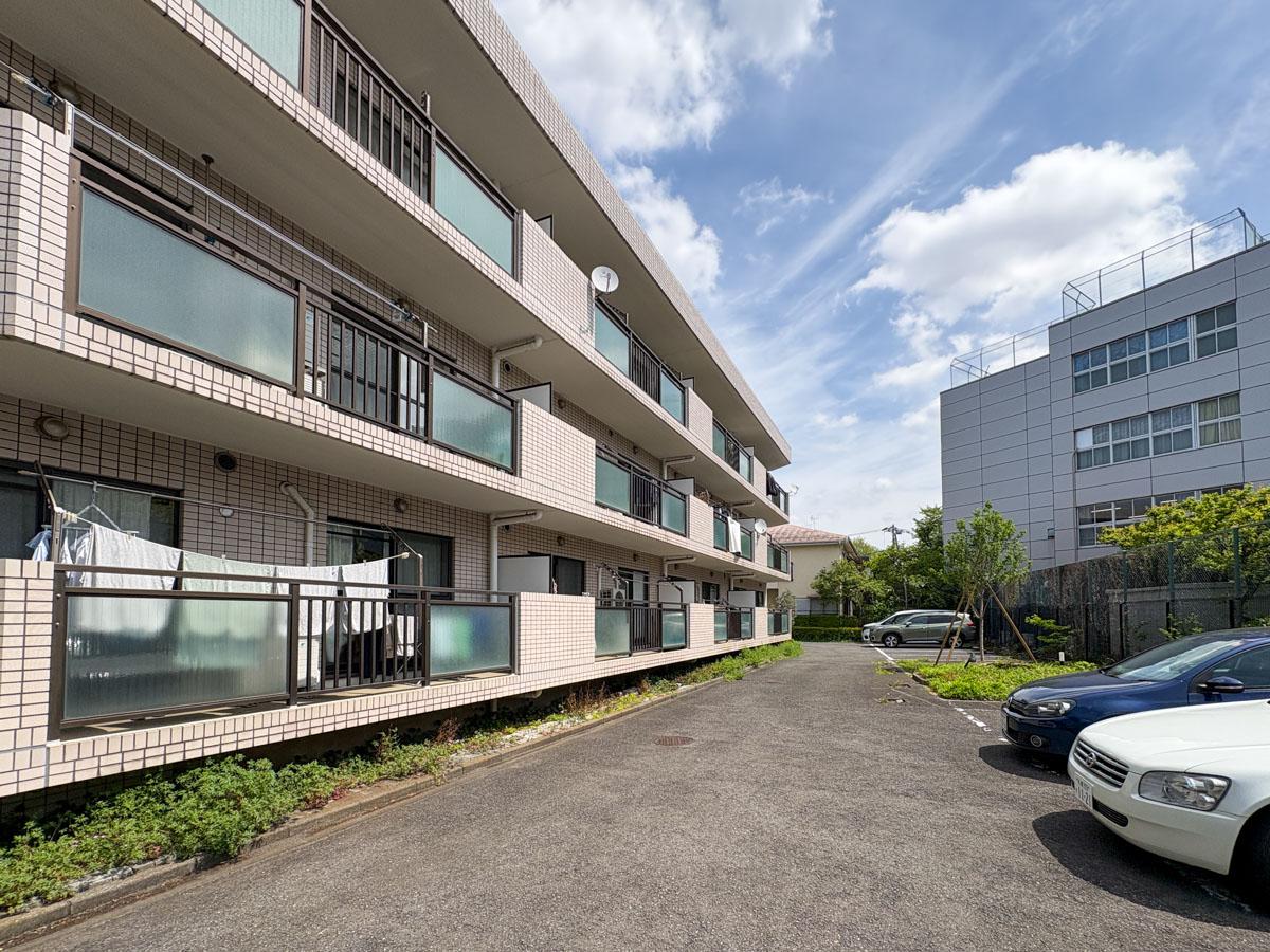 三鷹市牟礼の売買物件/オートロック内共用部分：駐車場別角度から　写真右手には学校があります。青春の音がする（現オーナーはうるさく感じたことはないそうです）