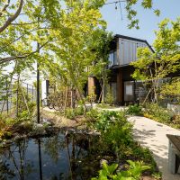 調布市深大寺東町の賃貸物件/中庭の池と、色とりどりの植栽が広がる