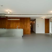 横浜市港北区師岡町の売買物件/キッチンの方をみる。木質の建具が無機質な空間によく馴染んでいます