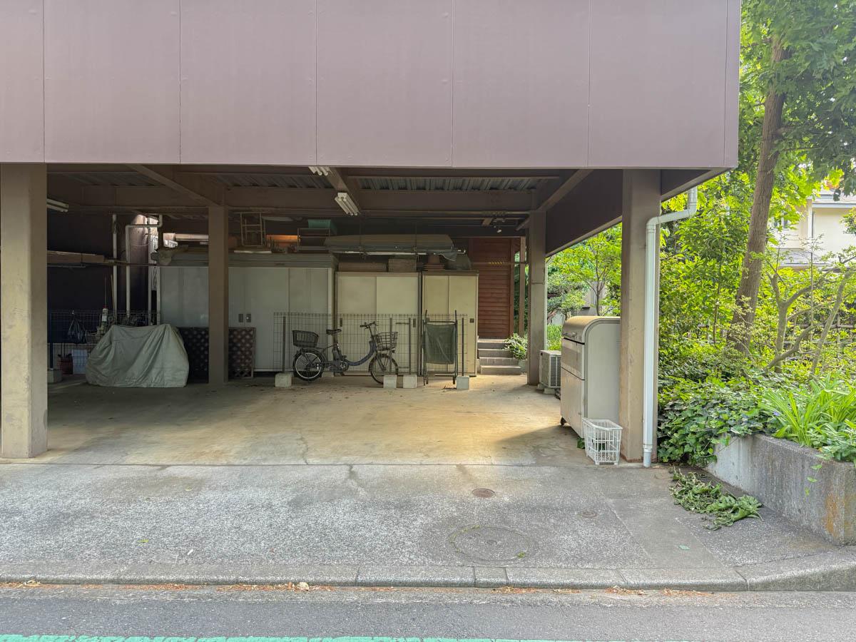 東久留米市学園町の賃貸物件/敷地へのアプローチは隠れ家的。この駐車場を通り抜けた先に建物が待っています。駐車場は月額10,000円で借りられます