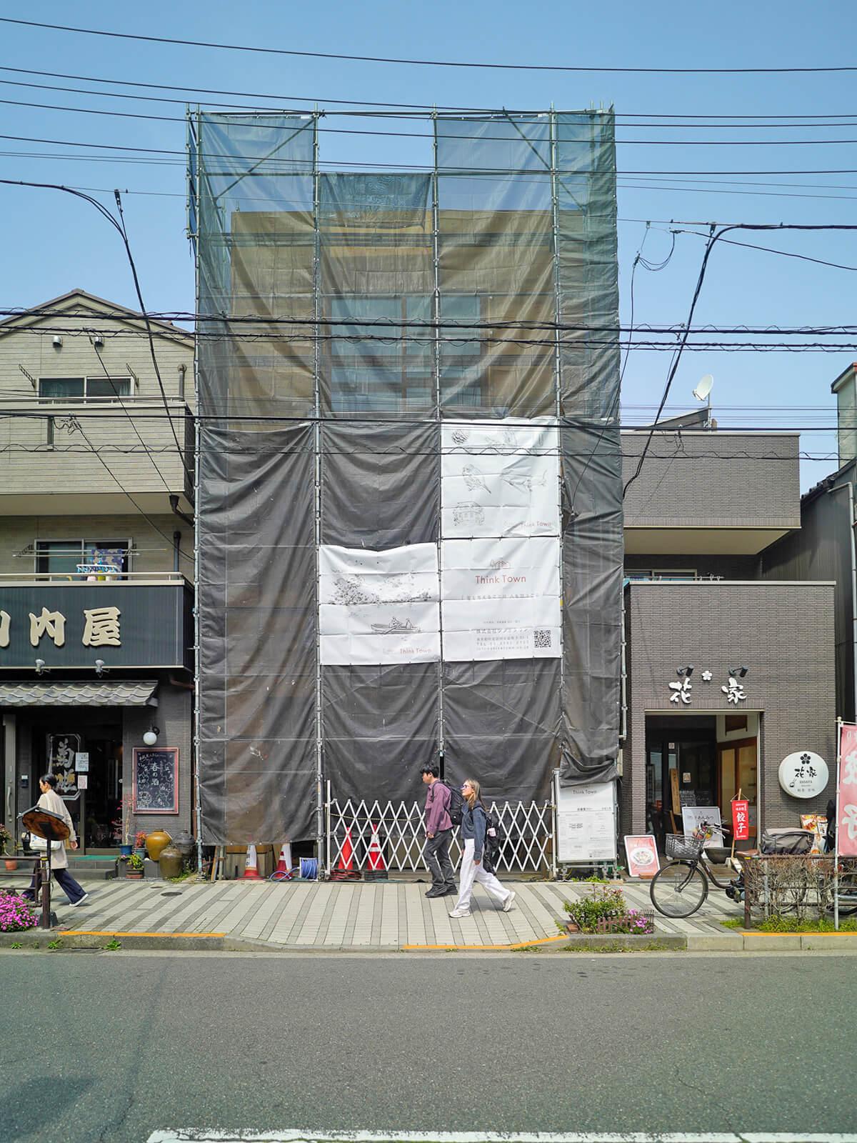 荒川区西日暮里の賃貸物件/現在の建物。工事中のため、囲いがありますが、うっすらと木造の建物が見えます
