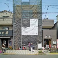 荒川区西日暮里の賃貸物件/現在の建物。工事中のため、囲いがありますが、うっすらと木造の建物が見えます