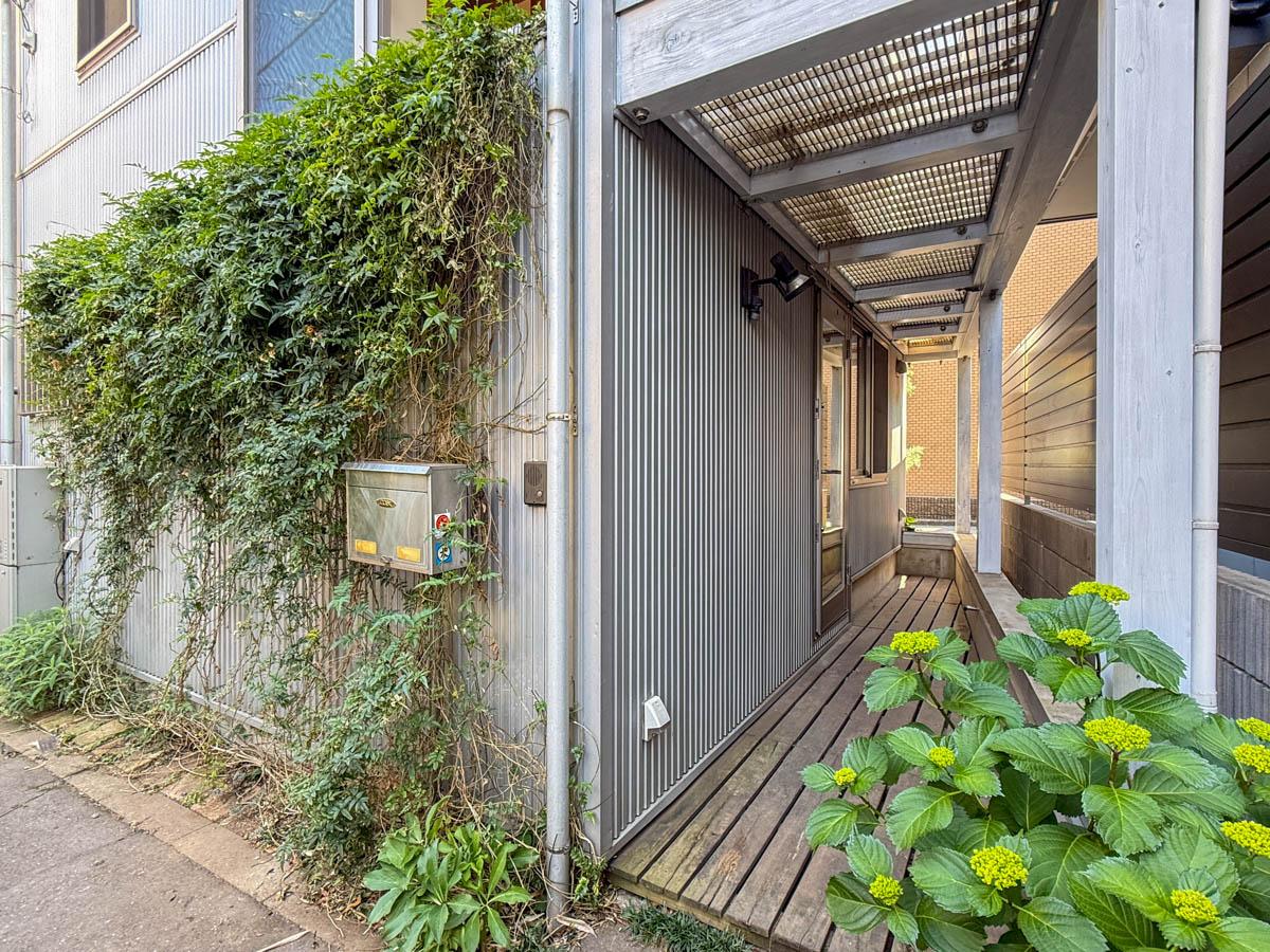 品川区小山台の売買物件/トンネル状のポーチが個性的。入口の紫陽花や床に敷かれたデッキの雰囲気がよい◎