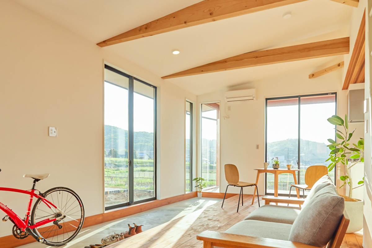 茨城県桜川市犬田の賃貸物件/平屋造りの1LDK。玄関入ってすぐ、オープンなリビングが待っている形。窓の先には水田の景色