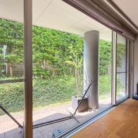 世田谷区砧の賃貸物件/リビングの窓はかなりワイド。タイル敷きのテラス、そしてその先に緑が茂るお庭スペース