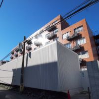 港区六本木の賃貸物件/赤茶のタイルが張られた6階建ての建物に、まるでコンテナのような白い低層の建物がくっついた不思議なつくり