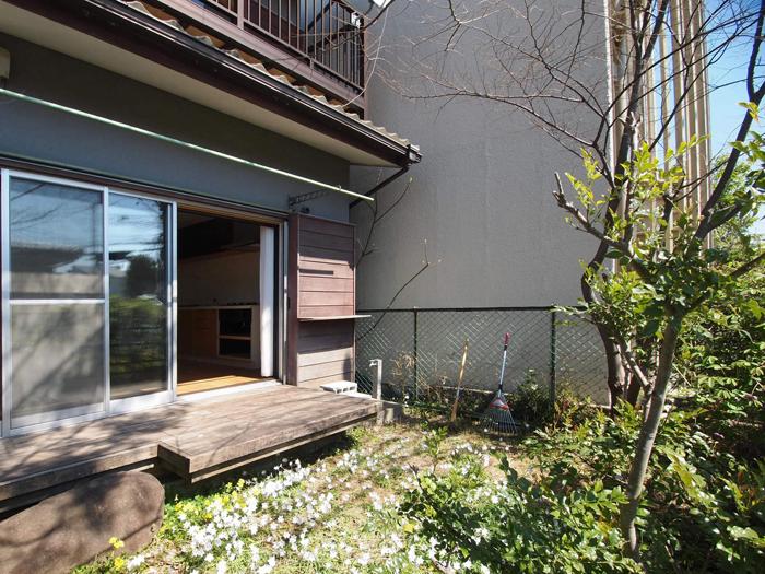 【庭】腰をかけるのにちょうどいいウッドデッキ。自由に草花や木が生えている感じがいい(3月撮影)