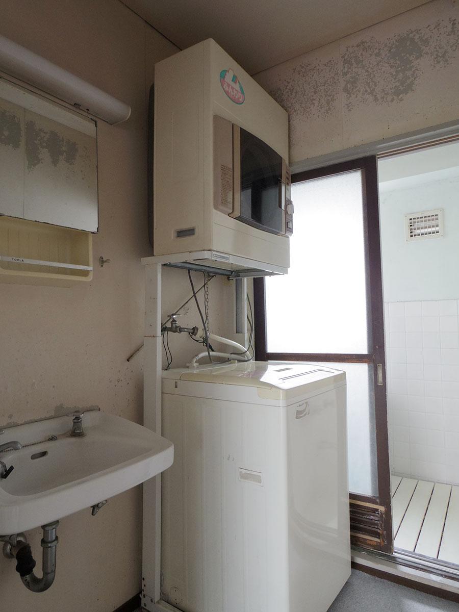 古めかしい洗面台。洗濯機と乾燥機は残置物扱いで撤去はご相談