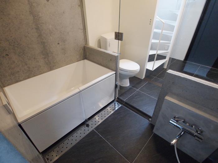 中野区南台の賃貸物件/浴室はガラス張り。玄関から統一された黒いタイルがかっこいいデザイン。追いだき機能がついている