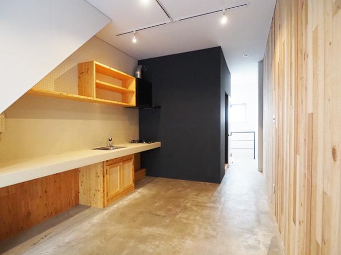 千代田区東神田の賃貸物件/造作したキッチンと無垢板の壁がスタイリッシュでかっこいい。床は土間のつくり