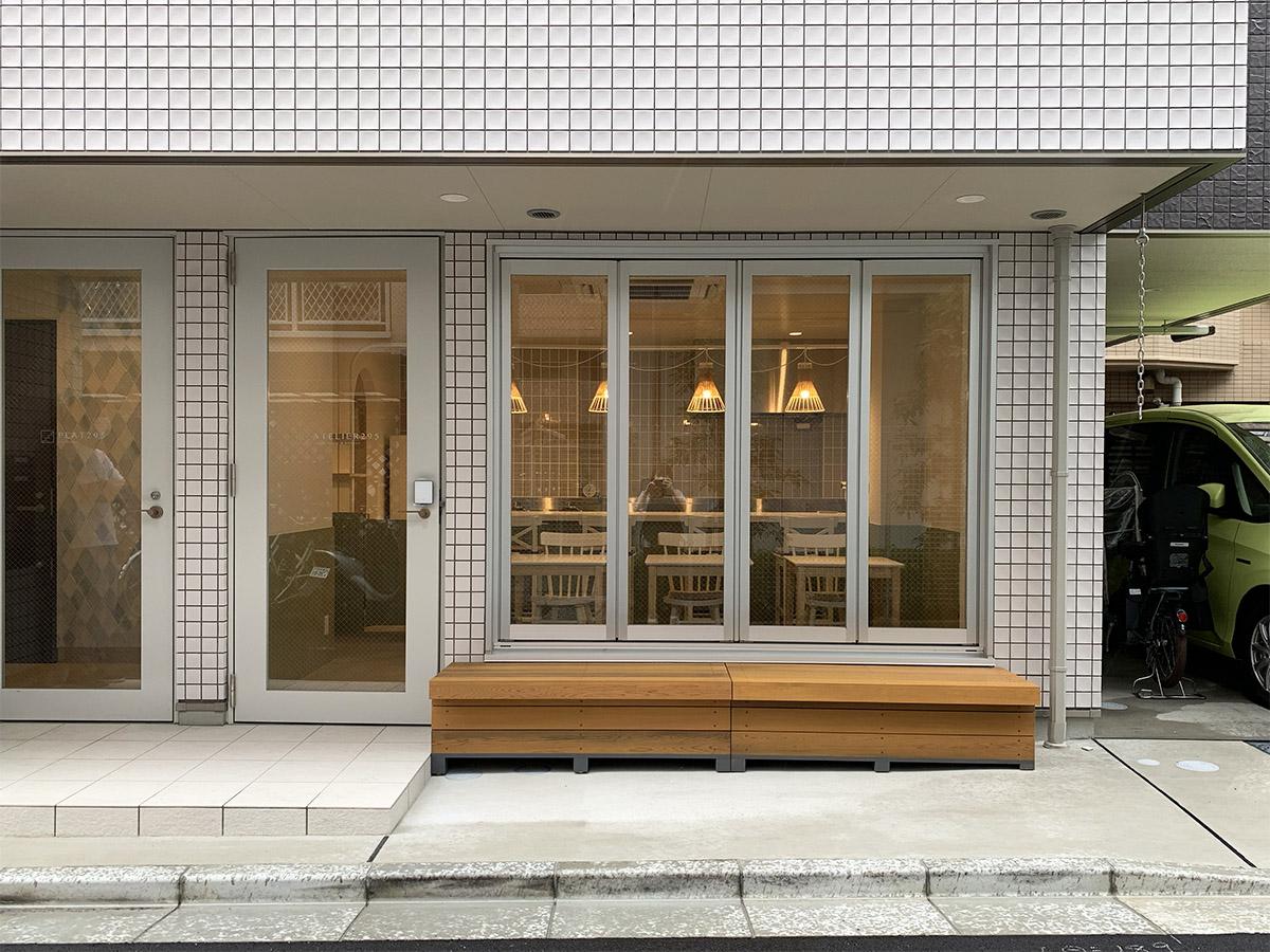 左のオートロックの扉から住居の共用部分。右側の区画はシェアキッチン。折れ戸を開ければ開放的に