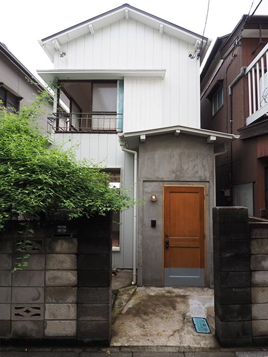 板橋区徳丸の賃貸物件/玄関扉は木製（今回メンテナンスで濃いめのグレーに塗装します）。その周りをモルタルで仕上げました