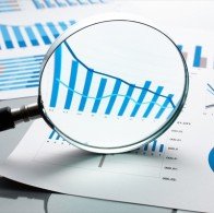Financial reports, documents and magnifying glass.