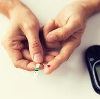 close up of man checking blood sugar by glucometer