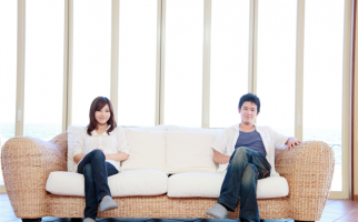 大きなソファに腰掛ける男女