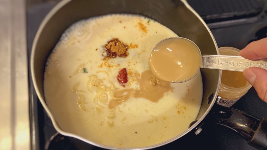 【サッポロみソイ坦々麺】 300mlのお湯で麺をほぐしながら3分茹でたら、付属の粉スープ.豆乳300ml.ねり胡麻大さじ2.豆板醤小さじ1/3.砂糖小さじ1/2.ラー油少々を加えて完成