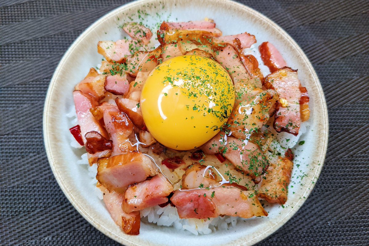 めんつゆペペロン丼】　  ①フライパンにごま油小さじ1を入れ弱火でベーコンとにんにくを炒める ②ベーコンが焼けたらめんつゆ、ブラックペッパー、唐辛子を入れ、軽く炒める ③ごはんの上にのせ卵黄、パセリをのせて完成  にんにくとめんつゆの味が染みたベーコンは超美味です