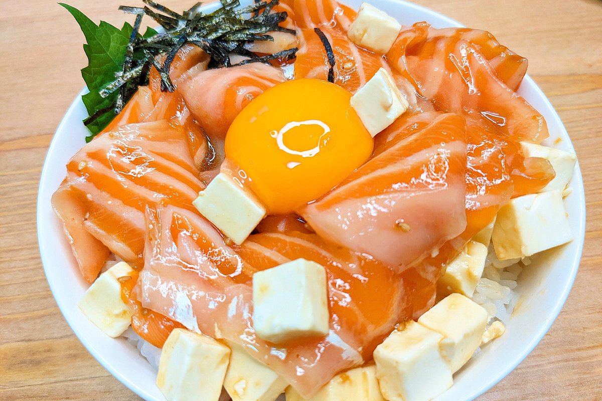 【至高のサーモンクリームチーズユッケ丼】 ①サーモンに焼肉のタレ、ごま油、白ごまを混ぜ20分漬ける ②①にクリームチーズを和える ③ごはんの上に大葉、②、卵黄、きざみのりをのせて完成 しっかり味がついたサーモンとなめらかなクリームチーズが最高に合います