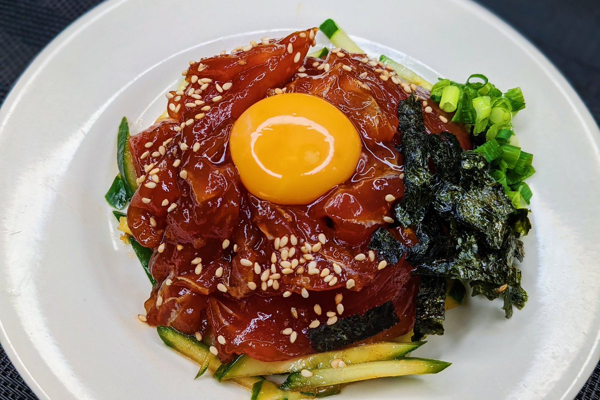 まぐろユッケ】  ①マグロをカットし、醤油、ごま油、コチュジャン、にんにく、生姜を混ぜ10分おく ②白ごまを加えてきゅうりの上にのせ卵黄、ネギ、のりをのせれば完成