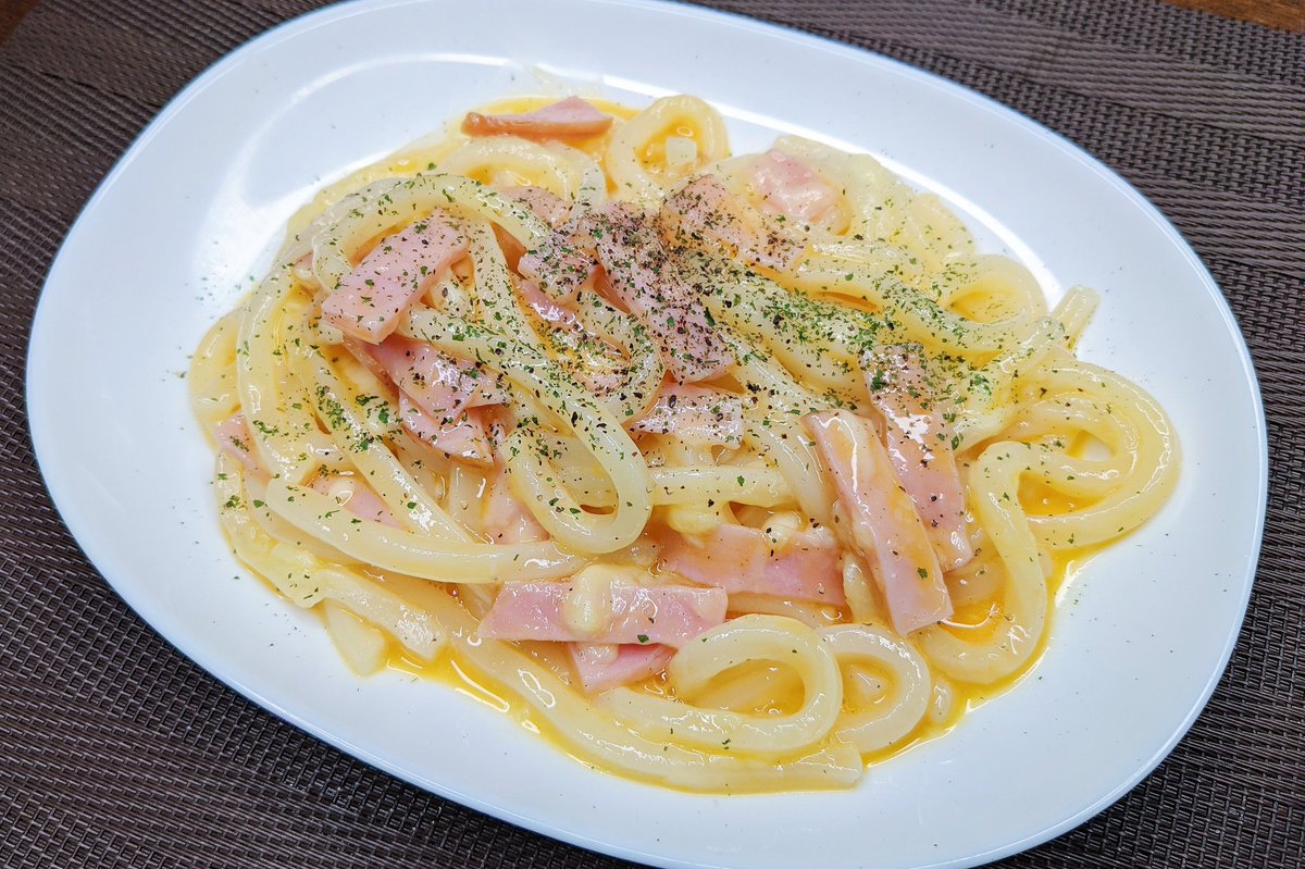 カルボナーラうどん】  ①冷凍のうどんを耐熱容器に入れ上にオリーブオイル、チーズ、ハムをのせてラップをして600W4分で温める ②卵を溶いて②と混ぜてブラックペッパー、パセリをかけて完成  めちゃめちゃ簡単でレンジだけでカルボナーラができます