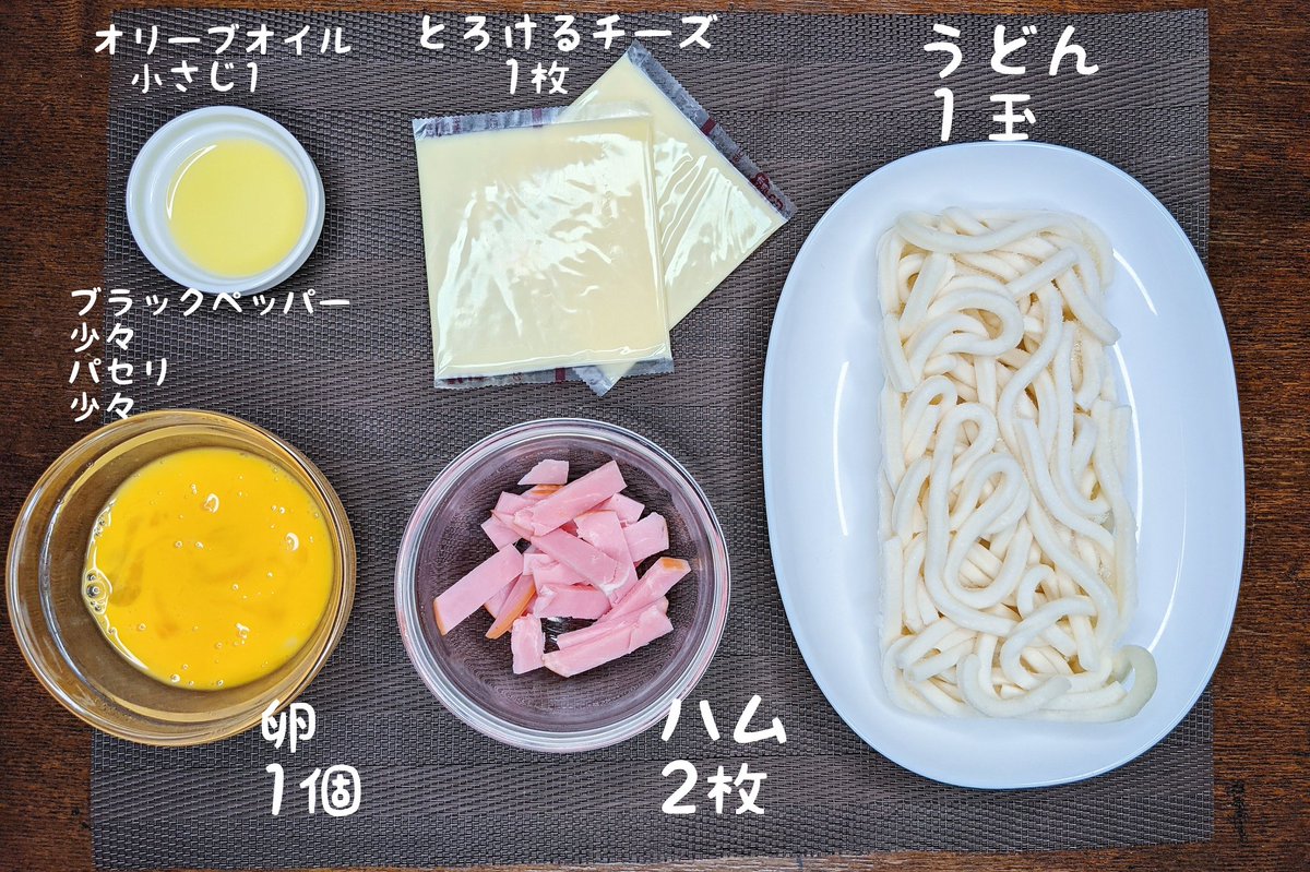 カルボナーラうどん】  ①冷凍のうどんを耐熱容器に入れ上にオリーブオイル、チーズ、ハムをのせてラップをして600W4分で温める ②卵を溶いて②と混ぜてブラックペッパー、パセリをかけて完成  めちゃめちゃ簡単でレンジだけでカルボナーラができます