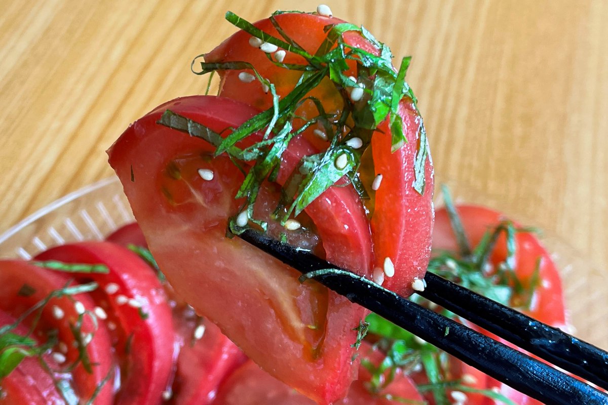 やみつき無限トマト  ①トマト3個を薄く半月型にスライス ②大葉1枚を細かく刻む ③鶏がらとにんにく各小さじ1を水小さじ1に溶かし、ごま油大さじ2とよく混ぜて特製ダレを作る ④お皿にトマトを盛り付け特製ダレをかけたら大葉と白ごまをふりかけて完成