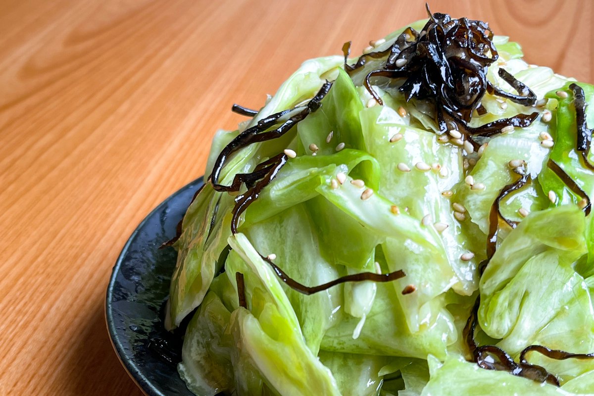 キャベツの塩こんぶ漬け】 ①キャベツを食べやすい大きさに手でちぎる ②ビニール袋に①をうつし、ごま油大さじ2、鶏がらスープとおろしにんにく各小さじ1、塩昆布ひとつまみを加えたら10分漬け置き ③お皿に盛り付け、最後に白ごまを乗せれば完成