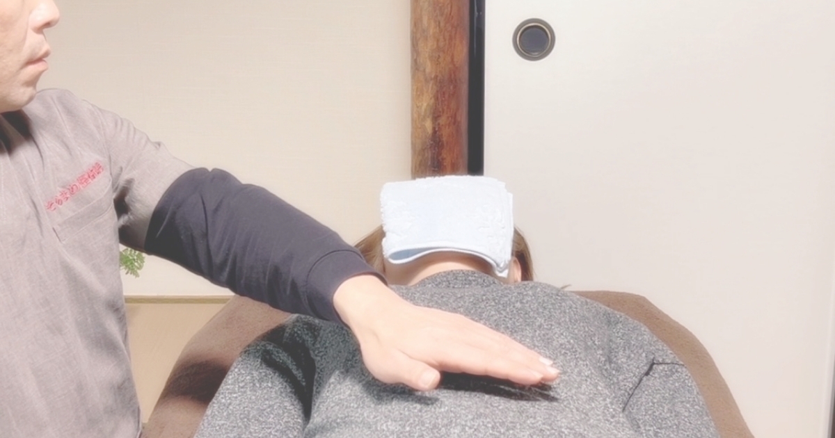 そらまめ整体院の和室で、施術者が背中に手を添えてレイキを行っている場面。静かな空間の中で心身が落ち着いていく様子を表現した写真。