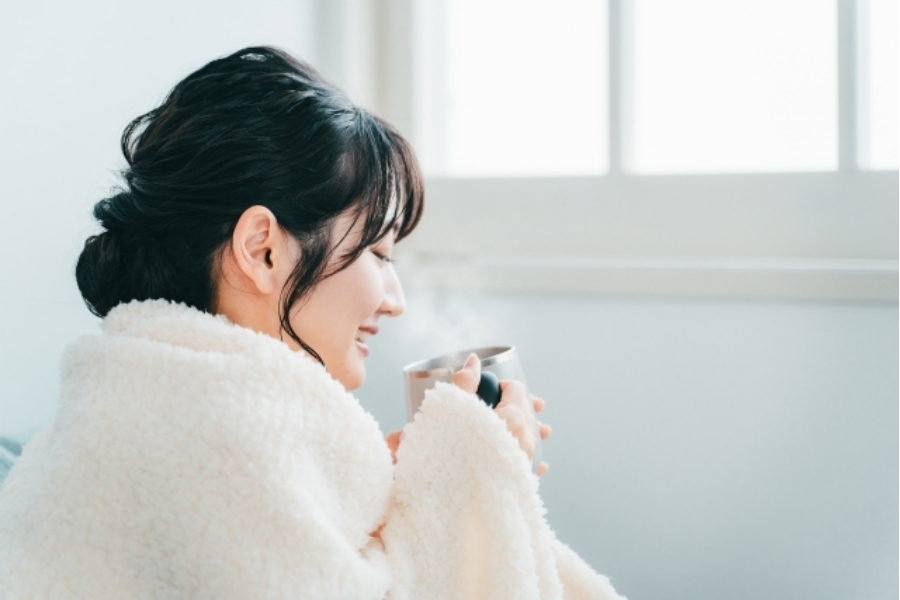 冬の冷え対策として体を温め、リラックスする女性。寒さによる自律神経の乱れと不眠の改善をイメージした写真。