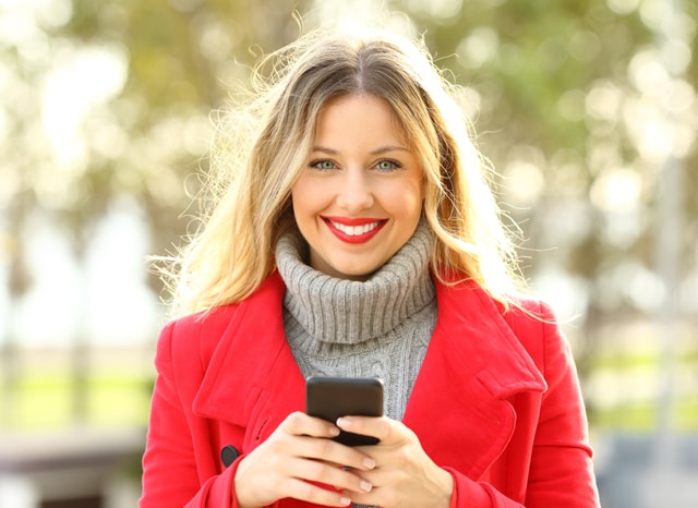笑顔でスマホを触る女性