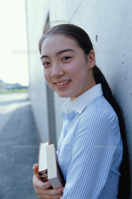 屋外の壁によりかかり本を抱える日本人の女の子
(c)KAZUO OGAWA/orion