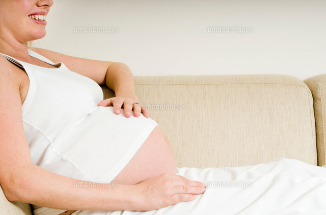 大きなおなかを抱える妊娠後期の女性 の写真素材 イラスト素材 アマナイメージズ