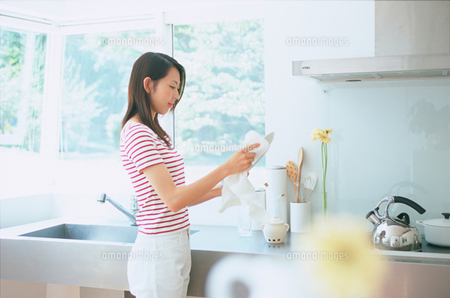 窓のあるキッチンで食器を拭く女性
(c)Katsutoshi Hatsuzawa/NEOVISION