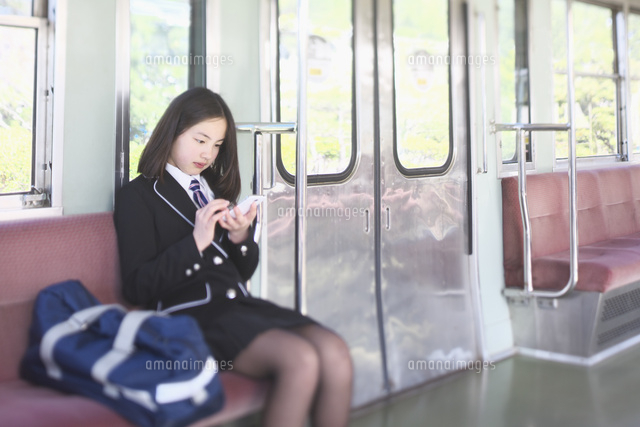 電車の中でスマートフォンを操作する女子中学生 10146003755 の写真