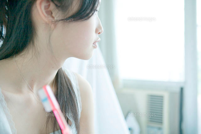 歯ブラシを持ち目をそらす若い女性
(c)absodels RF